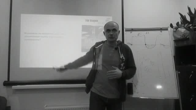 Антон Тарасов у флипчарта, рука к схеме на доске